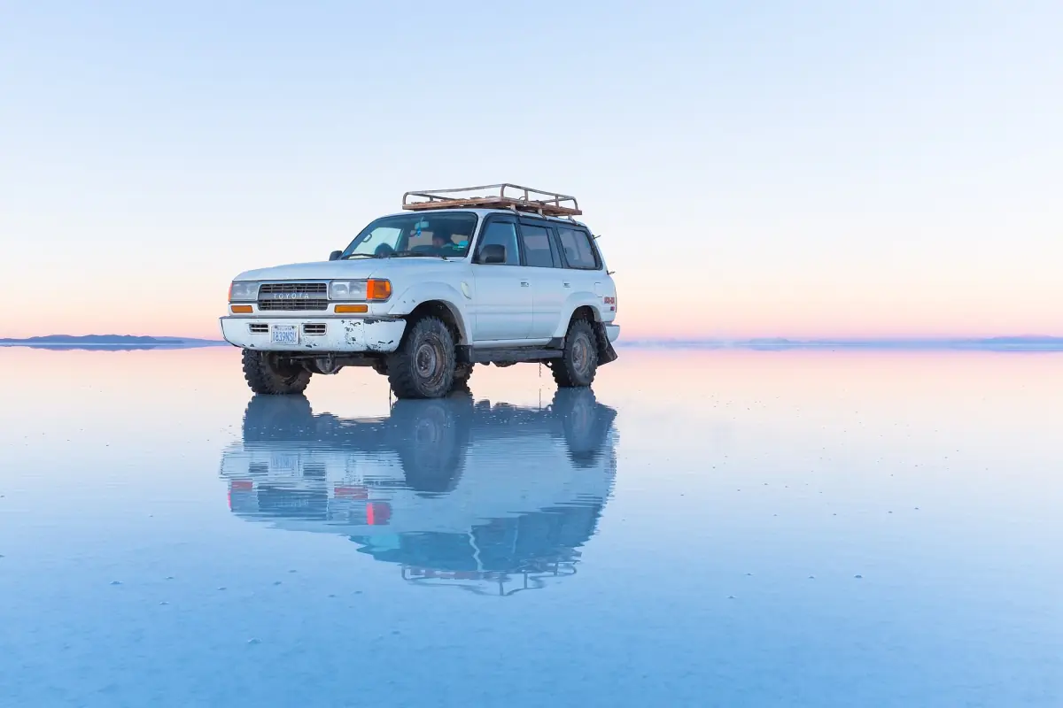 A jeep reflected on the flooded salt flat