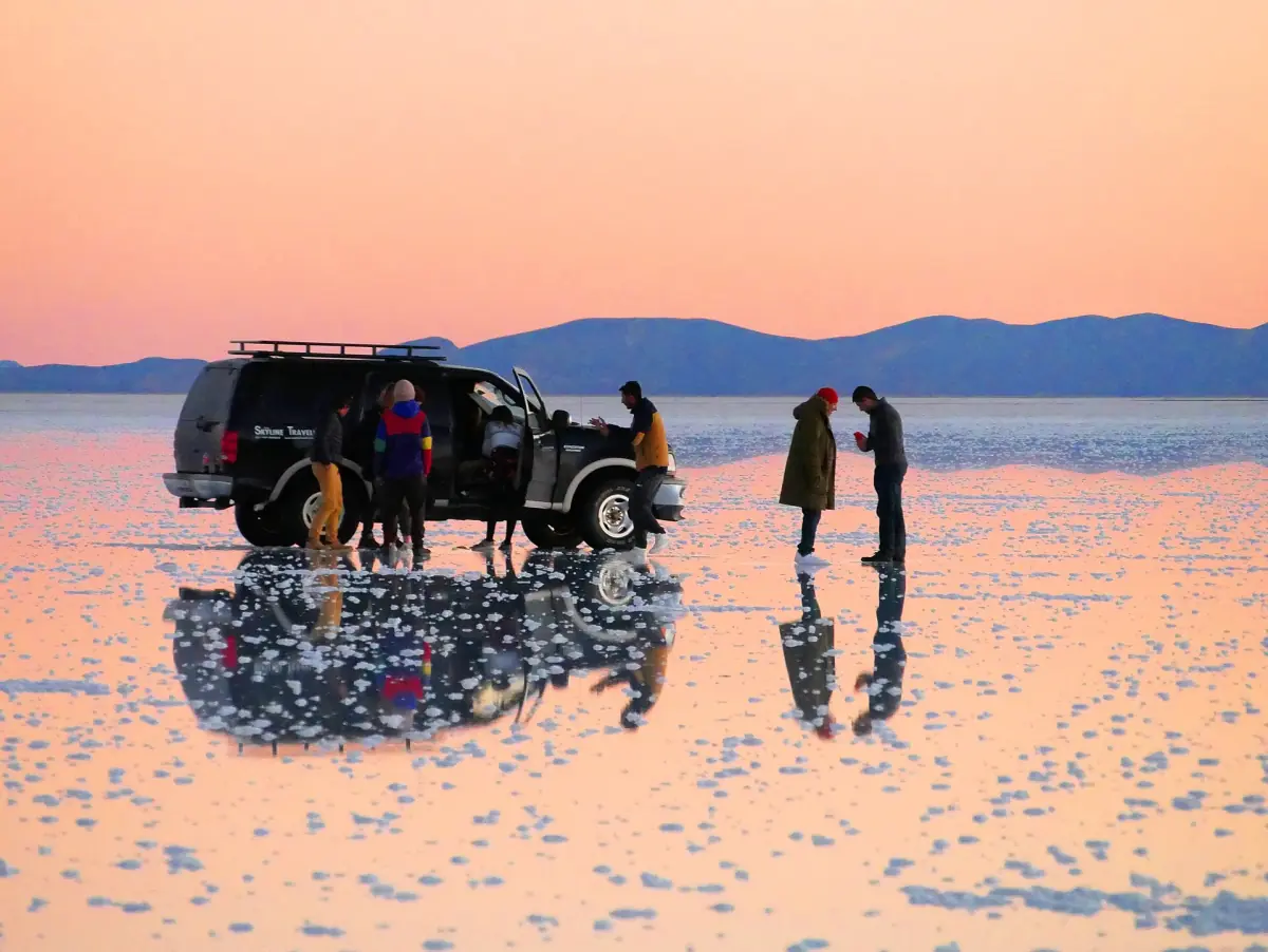 A tour group at sunset on the wet salt flat